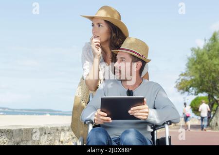 homme handicapé avec sa femme sur la plage Banque D'Images