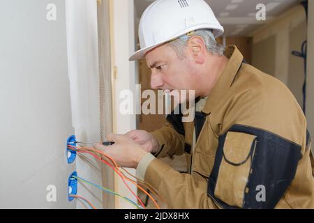 bon électricien travaillant sur la prise Banque D'Images