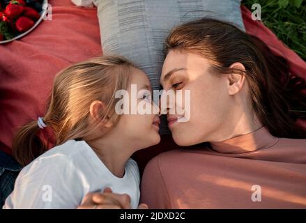 Une mère et une fille souriantes frottant le nez au pique-nique sur le terrain Banque D'Images