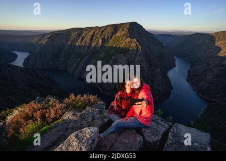 Couple heureux de prendre le selfie à travers le smartphone au sommet de la montagne Banque D'Images