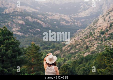 Femme portant un chapeau devant la chaîne montagneuse Banque D'Images