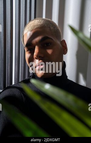 Jeune homme aux cheveux courts blond teint devant le mur Banque D'Images