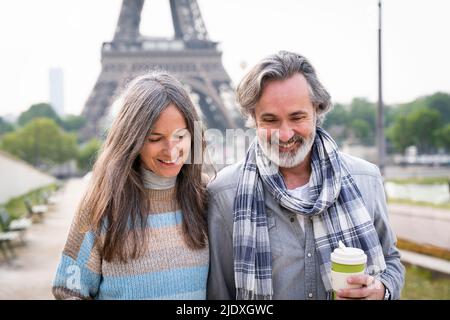 Heureux couple d'âge mûr en face de la tour Eiffel, Paris, France Banque D'Images