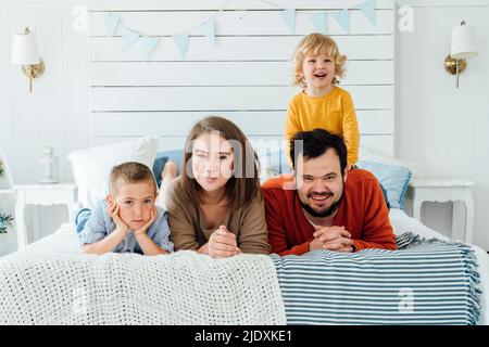 Happy Family lying together on bed at home Banque D'Images