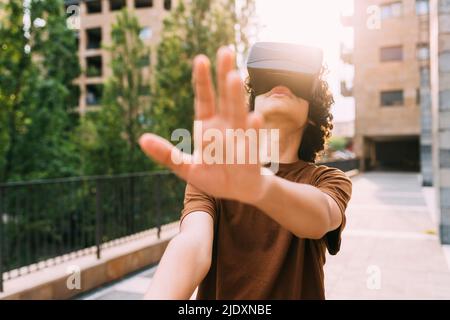 Garçon portant le simulateur de réalité virtuelle gesturant Banque D'Images