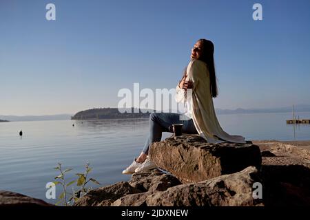 Femme se embrassant sur le rocher au bord du lac Banque D'Images