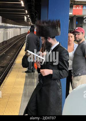 Un juif orthodoxe religieux attend un train F en direction de Brooklyn à la station de métro Broadway Lafayette à Manhattan, New York. Banque D'Images