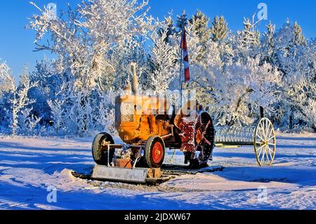 Un ancien tracteur agricole de Minneapolis Moline stationné comme pièce décorative dans le épais givre du nord de l'Alberta au Canada. Banque D'Images