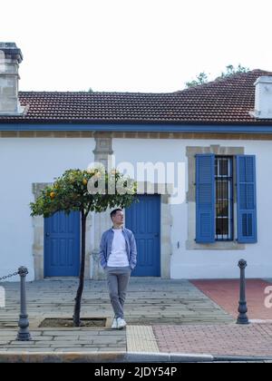 L'homme se trouve près d'un beau bâtiment avec des portes et des fenêtres bleues à Chypre Banque D'Images