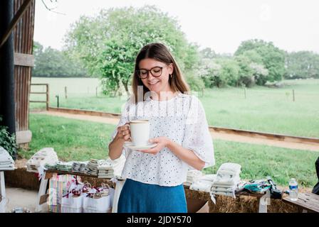 belle femme souriant tout en prenant une pause au travail en buvant un café Banque D'Images