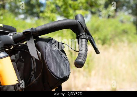 Sac de vélo sur le guidon d'un vélo dans les parcs en été au soleil, un vélo et des sacs sur un vélo, transport urbain en Ukraine Banque D'Images