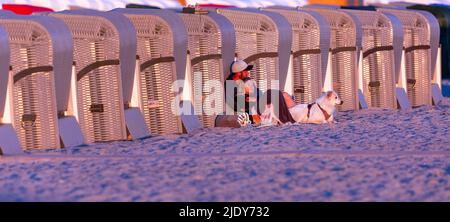 Rostock, Allemagne. 24th juin 2022. Les vacanciers regardent le soleil levant sur la plage de Warnemünde en début de matinée. Les météorologues s'attendent à de beaux temps d'été avec des températures allant jusqu'à 30 degrés dans les jours à venir. Credit: Jens Büttner/dpa/Alay Live News Banque D'Images