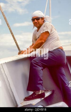 Un membre de l'équipage à bord du bateau de croisière TSS Fairstar utilisant un rouleau de peinture allongé sur la focsle. À l'origine un navire de troupe britannique Oxfordshire, elle a été convertie au Liner Fairstar (Sitmar) et a voyagé entre l'Angleterre et l'Australie jusqu'en 1974 quand elle a commencé des croisières à temps plein dans le Pacifique Sud jusqu'à son dernier voyage en 1997. Banque D'Images