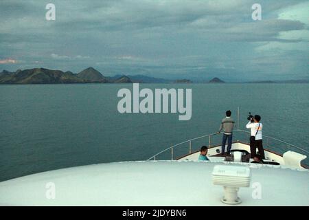 Passagers debout sur l'arc d'un bateau qui se dirige vers l'île Komodo dans la zone du parc national de Komodo à Komodo, à l'ouest de Manggarai, à l'est de Nusa Tenggara, en Indonésie. Banque D'Images