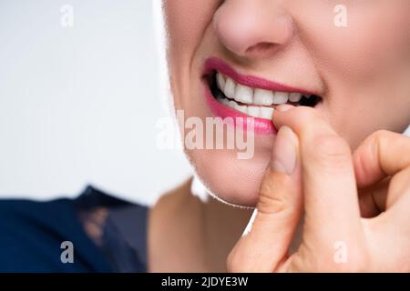 Close-up of a woman Biting son ongle Banque D'Images