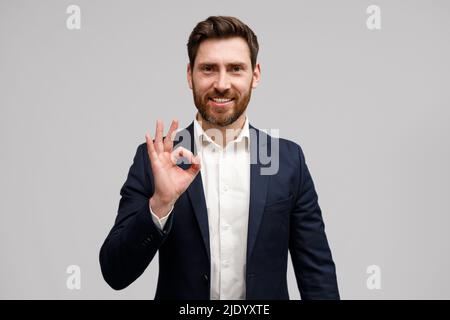 Homme en costume montrant le signe à la main que tout soit OK. Concept de réussite commerciale Banque D'Images