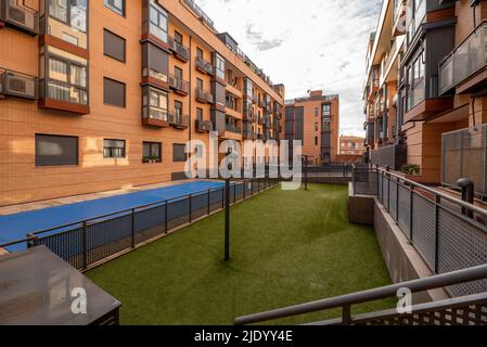 Espaces communs intérieurs avec sols en herbe artificielle et piscine intérieure dans un développement résidentiel urbain Banque D'Images