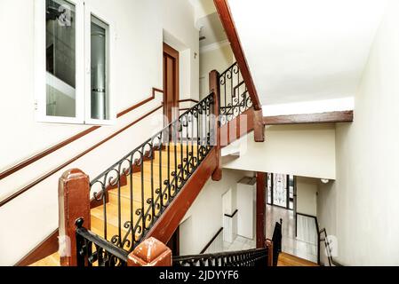 Escalier intérieur vintage avec marches en bois et balustrade en métal peint en bois et noir dans une ancienne maison Banque D'Images