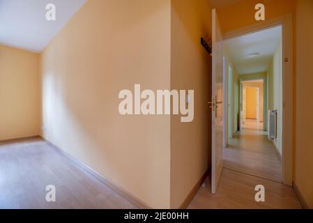 Chambre vide et hall de distributeur avec parquet en chêne, portes en bois et accès à plusieurs chambres Banque D'Images