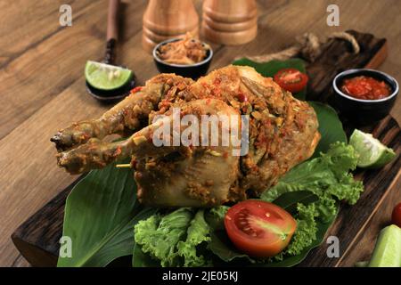 Ayam Betutu.Poulet rôti balinais farci de feuilles de manioc. Banque D'Images