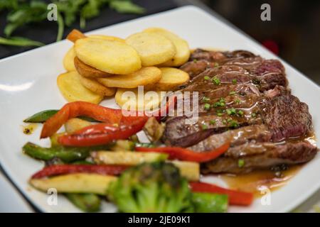 Délicieux repas avec des lanières de pike, des chips de pommes de terre et des légumes grillés sur une assiette blanche, savoureux plat comprenant plusieurs groupes alimentaires une puissance nutritionnelle Banque D'Images