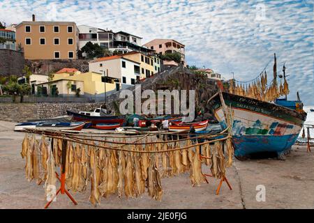 Stockfish accroché à la crémaillère, bateau de pêche, maisons, mer Baia de Camara de Lobos, Madère, officiellement région autonome de Madère, île, antique Banque D'Images