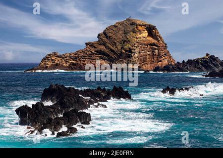Rochers non balayés par le surf à l'arrière petite île rocheuse Ilheu Mole avec phare Farol do Porto Moniz, mer, Madère, officiellement région autonome de Banque D'Images