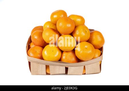Petite boîte en bois avec pile de mandarines riches et savoureuses isolées sur fond blanc. Banque D'Images