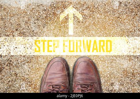 Texte pour UN PAS EN AVANT avec de vieilles chaussures en cuir marron sur le sol Banque D'Images