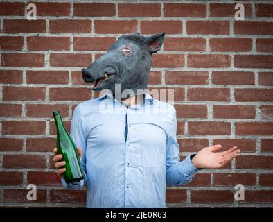 Homme d'affaires portant un masque de porc et contenant une bouteille de boisson alcoolisée Banque D'Images
