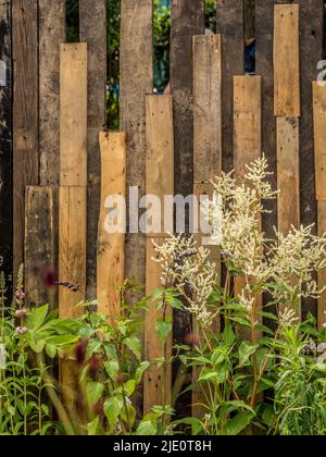 Clôture de jardin en bois faite de vieilles palettes défabriquées recyclées. Banque D'Images