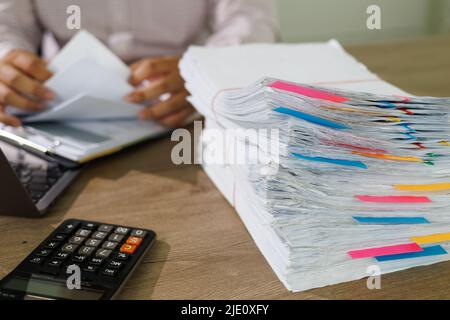 Document de concept de documents d'affaires atteint sur les papiers de dossiers dans le bureau de travail occupé Banque D'Images