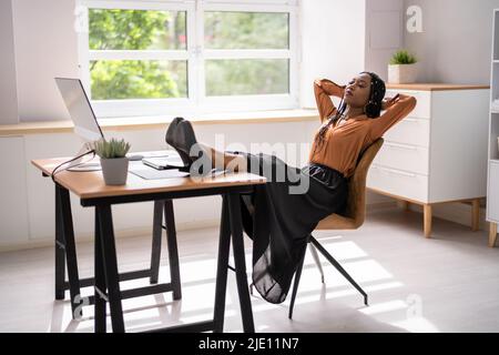 Vue latérale d'une jeune femme d'affaires décontractée assise au bureau Banque D'Images