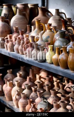 Beaucoup de cruches et vases en argile uniques et colorés faits à la main de formes diverses sur l'étagère dans le marché local Banque D'Images