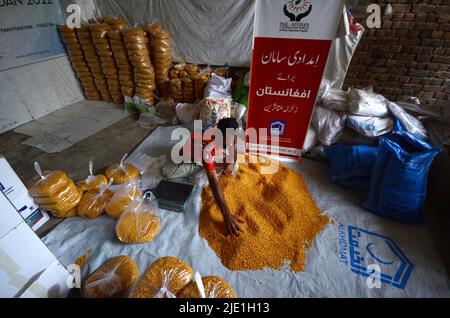 Peshawar, Pakistan. 23rd juin 2022. Les travailleurs de la Fondation Alkhidmat chargent des secours dans des camions de livraison pour les victimes du tremblement de terre afghan à Chamkani. Plus de 1 000 personnes ont été tuées et plus de 1 500 autres blessées après un séisme de magnitude 5,9 qui a frappé l'est de l'Afghanistan avant l'aube le 22 juin, a rapporté l'agence de presse nationale de Bakhtar. Selon les autorités, le nombre de morts devrait augmenter. (Photo de Hussain Ali/Pacific Press) crédit: Pacific Press Media production Corp./Alay Live News Banque D'Images