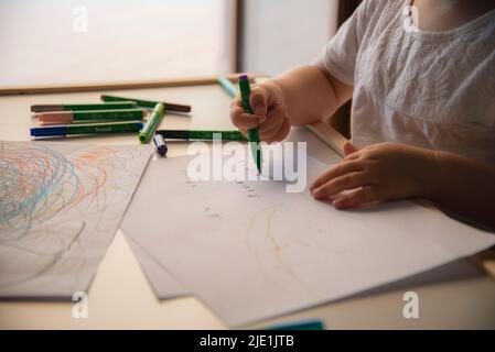 Enfant dessinant des formes colorées sur du papier blanc. Éducation scolaire des enfants. Photo de haute qualité Banque D'Images