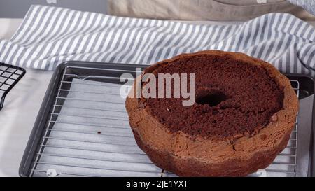 Étape par étape. Refroidir le gâteau au chocolat fraîchement cuit sur une grille de refroidissement. Banque D'Images
