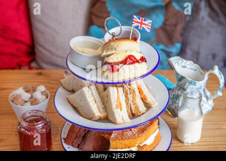 Thé à la crème de Cornouailles du Devon sur une table avec scone, crème et confiture, sandwichs et drapeau syndical Banque D'Images