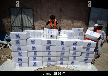 Peshawar, Pakistan. 23rd juin 2022. Les travailleurs de la Fondation Alkhidmat chargent des secours dans des camions de livraison pour les victimes du tremblement de terre afghan à Chamkani. Plus de 1 000 personnes ont été tuées et plus de 1 500 autres blessées après un séisme de magnitude 5,9 qui a frappé l'est de l'Afghanistan avant l'aube le 22 juin, a rapporté l'agence de presse nationale de Bakhtar. Selon les autorités, le nombre de morts devrait augmenter. (Photo de Hussain Ali/Pacific Press/Sipa USA) crédit: SIPA USA/Alay Live News Banque D'Images