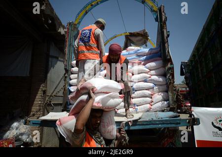 Peshawar, Pakistan. 23rd juin 2022. Les travailleurs de la Fondation Alkhidmat chargent des secours dans des camions de livraison pour les victimes du tremblement de terre afghan à Chamkani. Plus de 1 000 personnes ont été tuées et plus de 1 500 autres blessées après un séisme de magnitude 5,9 qui a frappé l'est de l'Afghanistan avant l'aube le 22 juin, a rapporté l'agence de presse nationale de Bakhtar. Selon les autorités, le nombre de morts devrait augmenter. (Photo de Hussain Ali/Pacific Press/Sipa USA) crédit: SIPA USA/Alay Live News Banque D'Images