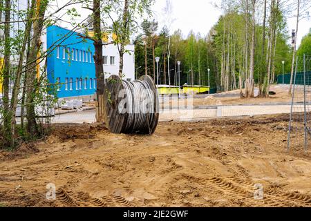 une bobine en bois avec un câble électrique est située sur un chantier de construction Banque D'Images