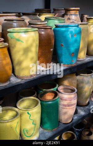 Beaucoup de cruches et vases en argile uniques et colorés faits à la main de formes diverses sur l'étagère dans le marché local Banque D'Images