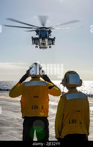 OCÉAN PACIFIQUE (22 juin 2022) compagnon de bateau d'aviation (manutention) Airman Stephone Scotland, de New York, à gauche, sous instruction du compagnon de bateau d'aviation (manutention) Airman Garrett Solomon, de Ewa Beach, Hawaii, à droite, ), Signale à un super étalon CH-53E attaché au Escadron d'hélicoptères lourds maritimes (HMH) 462, pendant les opérations de vol à bord d'Essex, 22 juin 2022. Essex mène actuellement des opérations de routine dans la flotte américaine 3rd. (É.-U. Navy photo par Mass communication Specialist 3rd Class Isaak Martinez) Banque D'Images