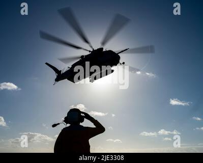 AVIATION DE L'OCÉAN PACIFIQUE (22 juin 2022) compagnon de bateau (manutention) Airman Garrett Solomon, de Ewa Beach, Hawaï, affecté au navire d'assaut amphibie USS Essex (LHD 2), salue un super étalon CH-53E, attaché au Squadron d'hélicoptère lourd marin (HMH) 462, pendant les opérations de vol à bord d'Essex, 22 juin 2022. Essex mène actuellement des opérations de routine dans la flotte américaine 3rd. (É.-U. Navy photo par Mass communication Specialist 3rd Class Isaak Martinez) Banque D'Images