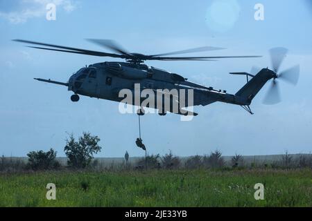 Des Marines et des soldats américains se déchargent d'un super étalon CH-53E lors d'un exercice au sein de Gunslinger 22 à Riley, Kansas, 21 juin 2022. Marines, avec la Compagnie de liaison des tirs de la Marine aérienne 2nd, le Groupe d'information de la Force expéditionnaire maritime II, la Réserve des Forces maritimes, et des soldats du 10th Escadron des opérations de soutien aérien, ont opéré les uns à côté des autres dans un exercice de cordage rapide au sein de Gunslinger 22. L'exercice Gunslinger 22 est un exercice conjoint avec la garde nationale de l'air du Kansas et le corps des Marines des États-Unis conçu pour augmenter le contrôle des aéronefs et l'entraînement pour les éventuelles éventualités du monde réel. (É.-U. M Banque D'Images