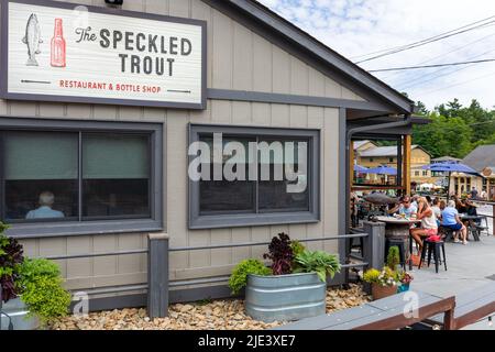 BLOWING ROCK, NC, USA-20 JUIN 2022 : restaurant et boutique de bouteilles Speckled Trout, avec dîner à l'extérieur. Construire, signer et clients. Banque D'Images