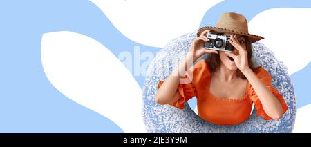 Jeune femme avec appareil photo et grand donut doux sur fond de couleur Banque D'Images