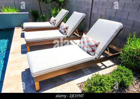 Trois chaises longues réglables près de la piscine Banque D'Images