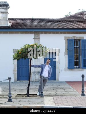 L'homme se trouve près d'un beau bâtiment avec des portes et des fenêtres bleues à Chypre Banque D'Images