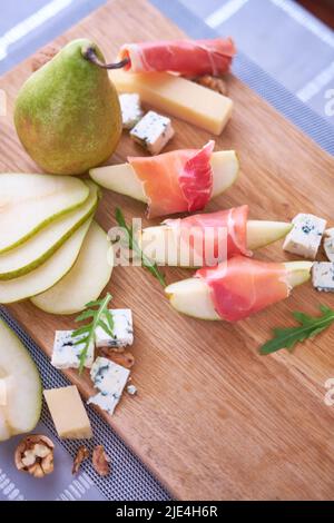 Tranches de jambon de Jamon ou de prosciutto, fromage bleu, poires et noix sur bois Banque D'Images